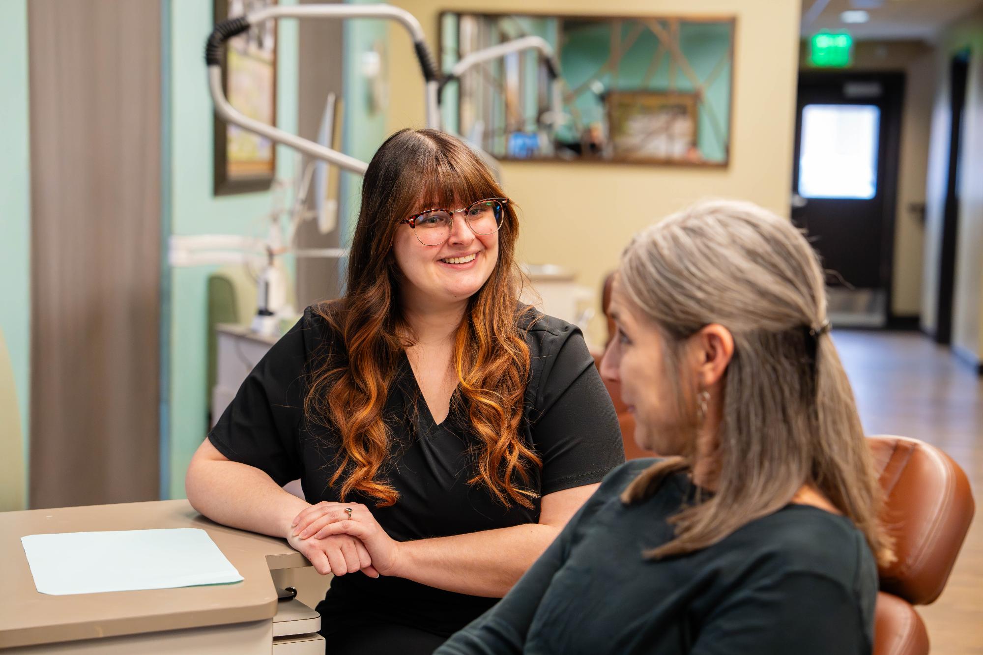 Smiling team member at New Braunfels Orthodontic Associates talking with a patient during a visit for New Braunfels orthodontics with Dr. Larry Layfield